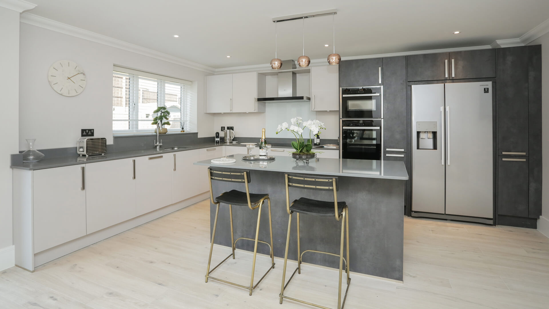 Fitted grey and white kitchen with breakfast bar at Woodside court.