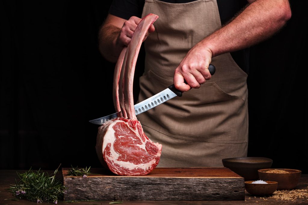 Chef cutting up a tomahawk steak