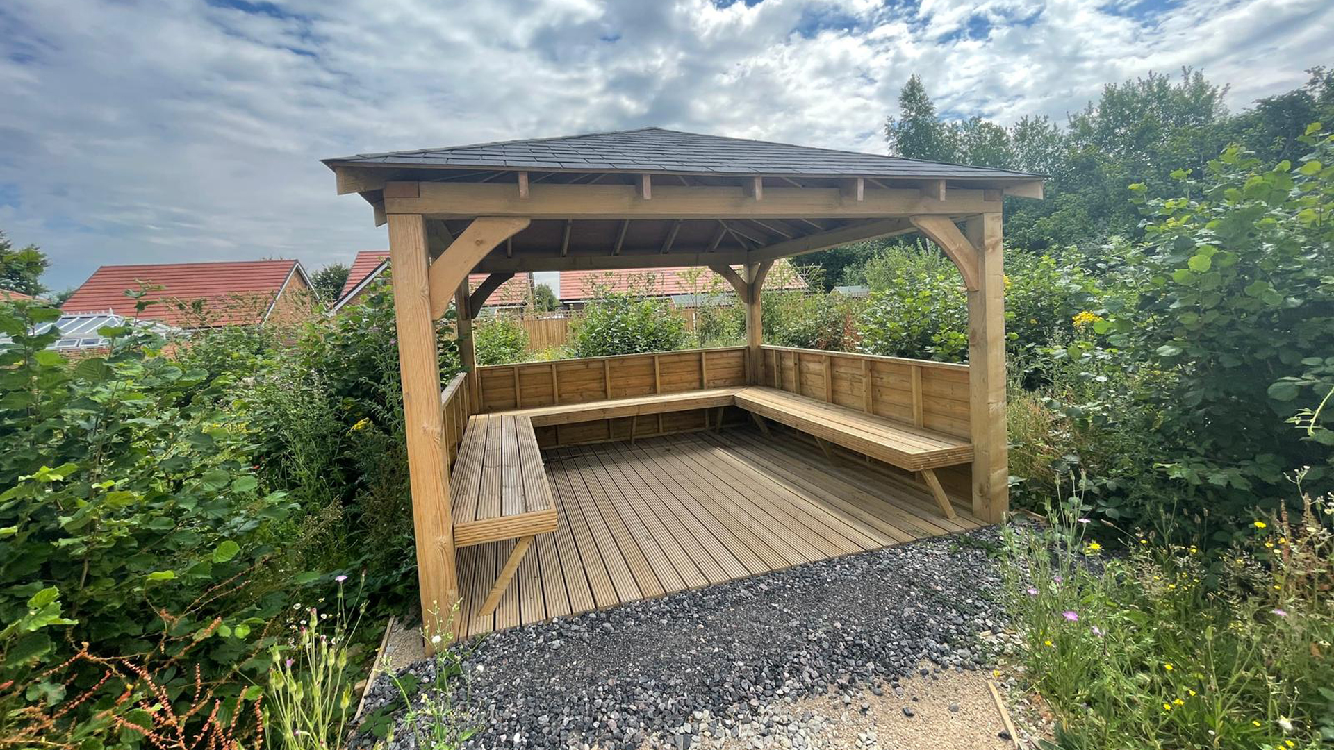 wooden gazebo seating area surrounded by wildflower