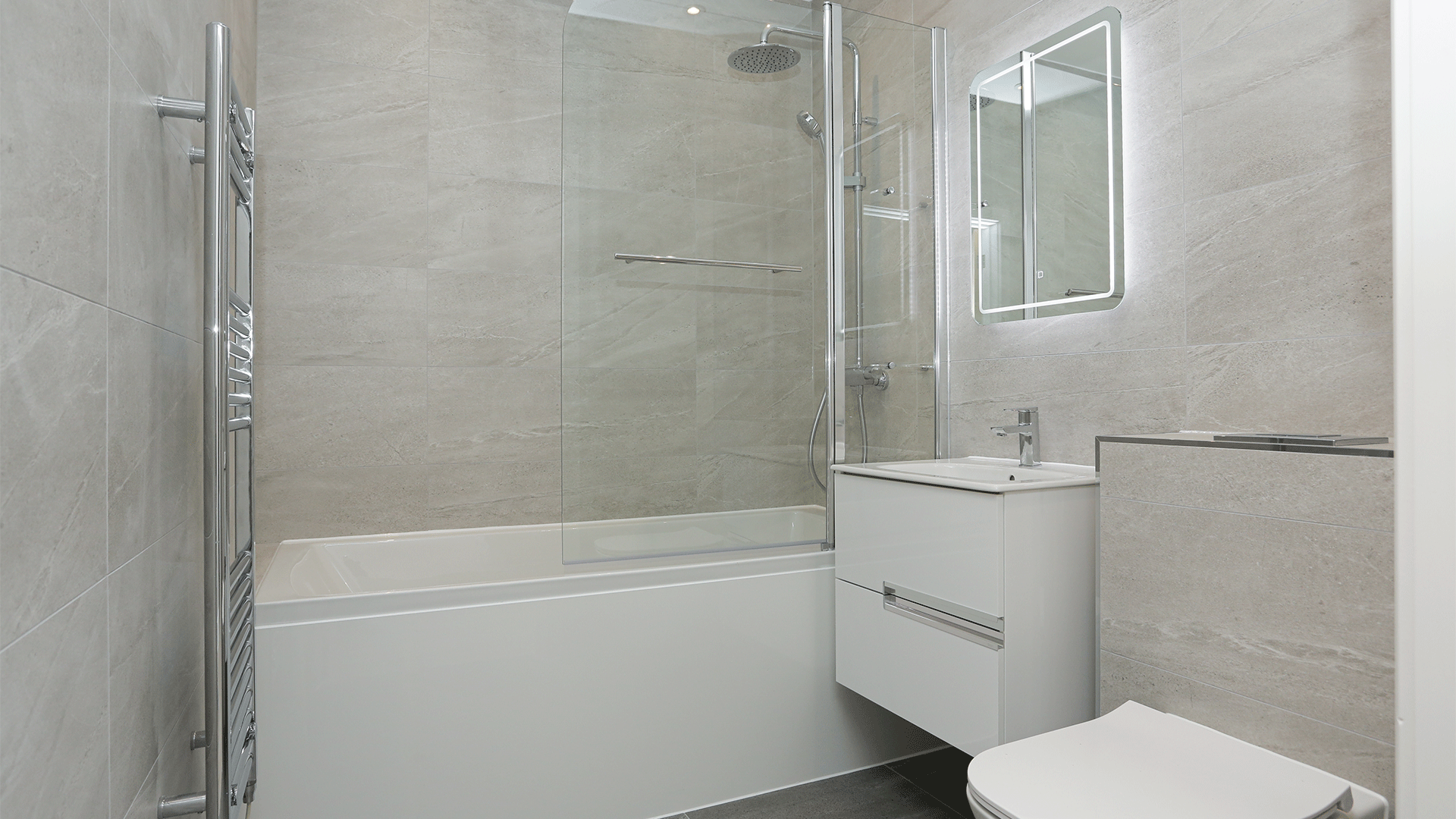 Tiled bathroom with shower, toilet, bath and sink basin with mirror at Miller's Meadow
