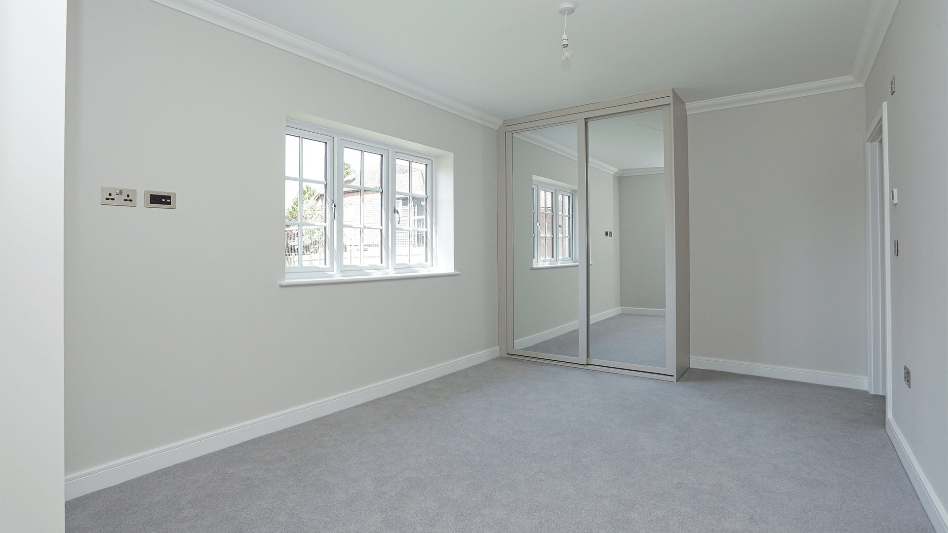 Bedroom with beige carpet, white walls and fitted wardrobe at Miller's Meadow