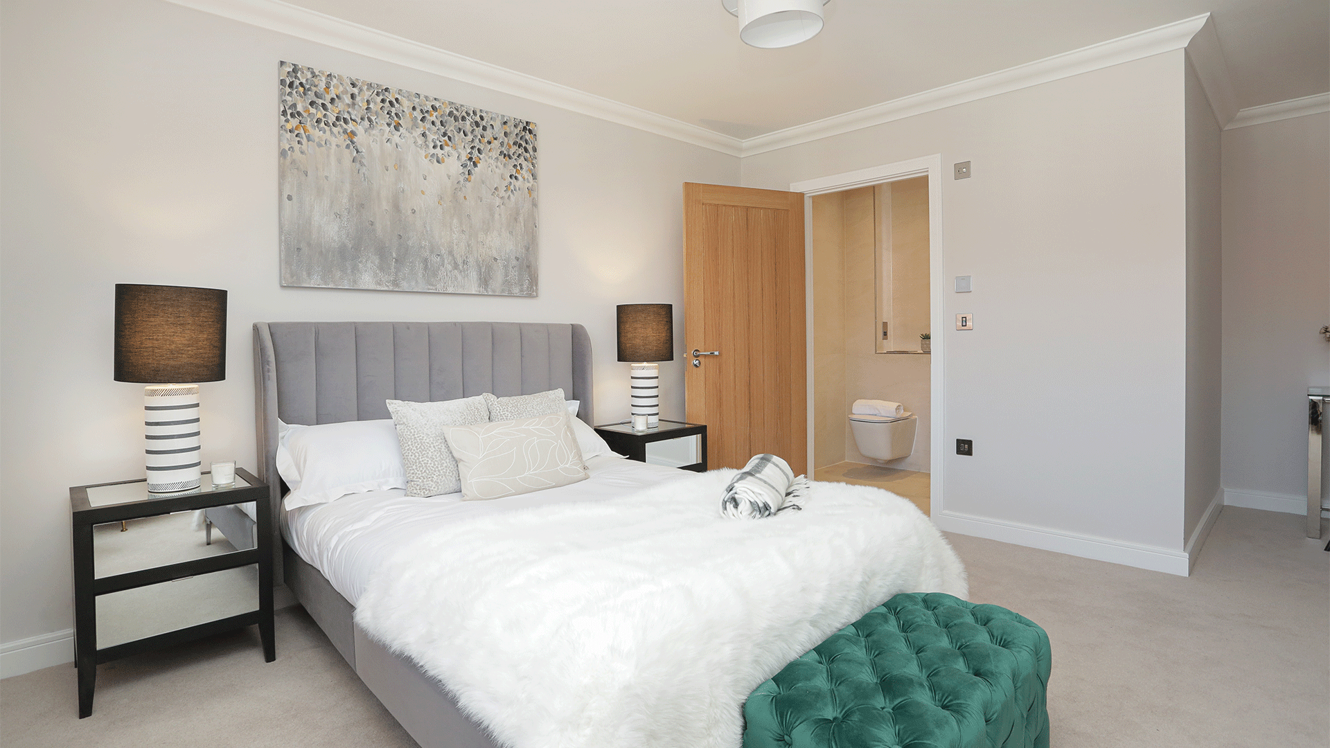 Miller's Meadow plot 8 Bedroom 2 with the en suite, bed, artwork and bedside tables and lamps
