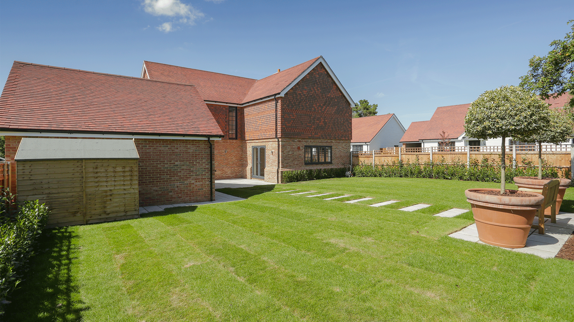 Miller's Meadow - Plot 8 Garden with a stone pathway and facing the back of the large detached house
