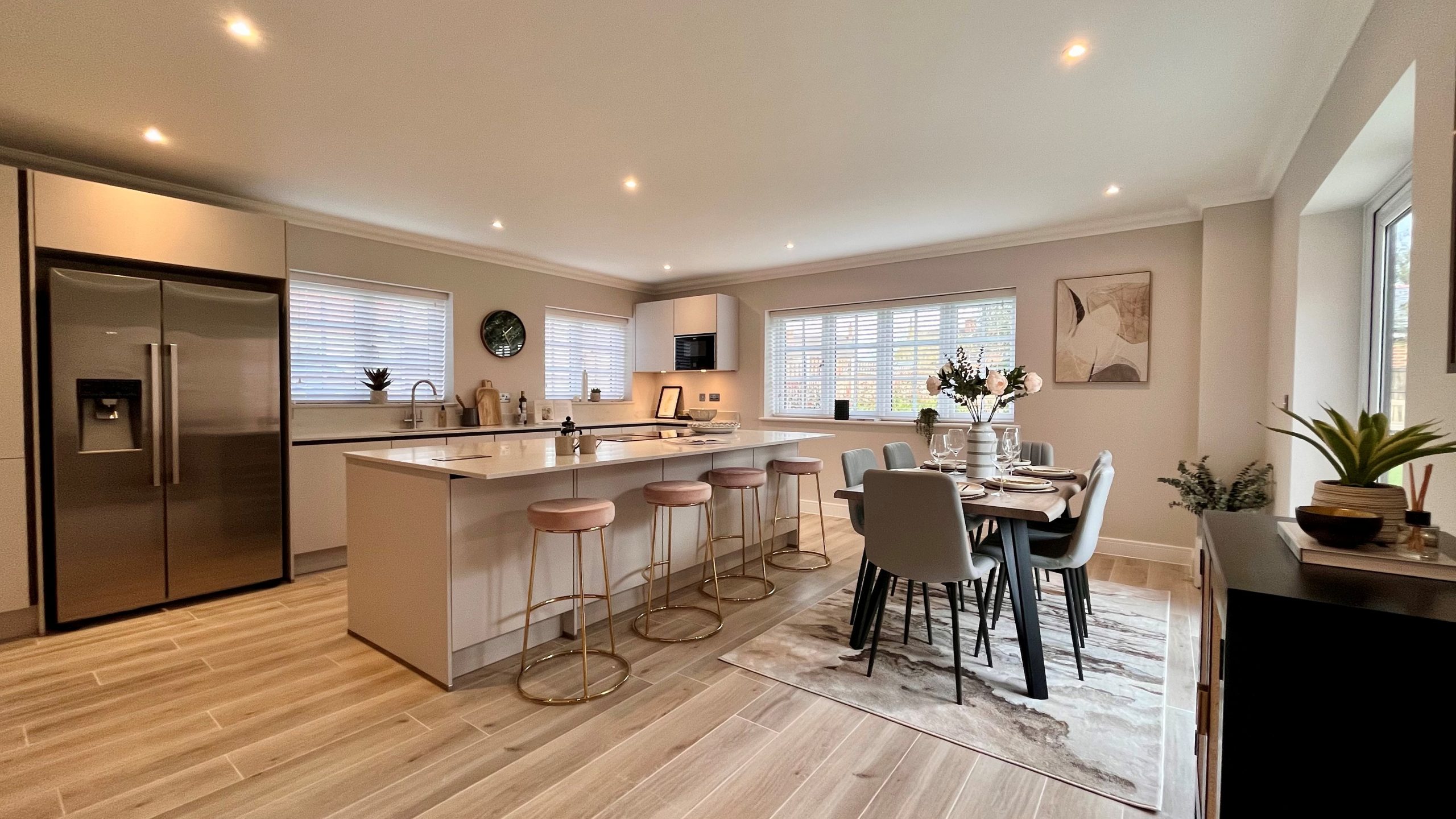 White worktop kitchen with spotlights and wooden dining table on a rug