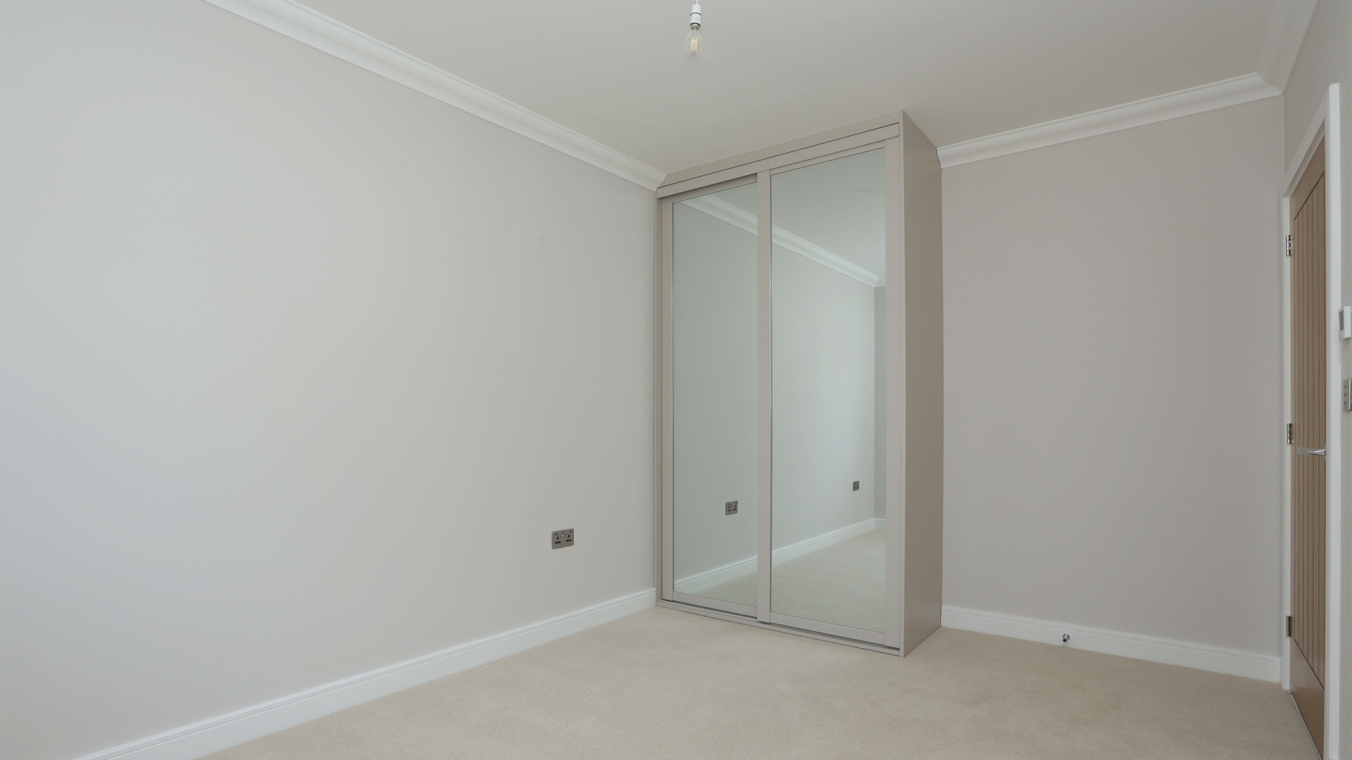 Bedroom with beige carpet, white walls and fitted wardrobe at Miller's Meadow