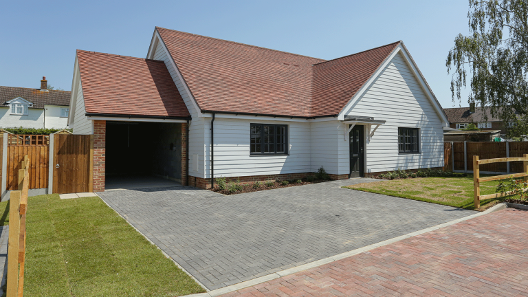 New build bungalow with landscaped front lawn, car barn and driveway at Miller's Meadow plot 9