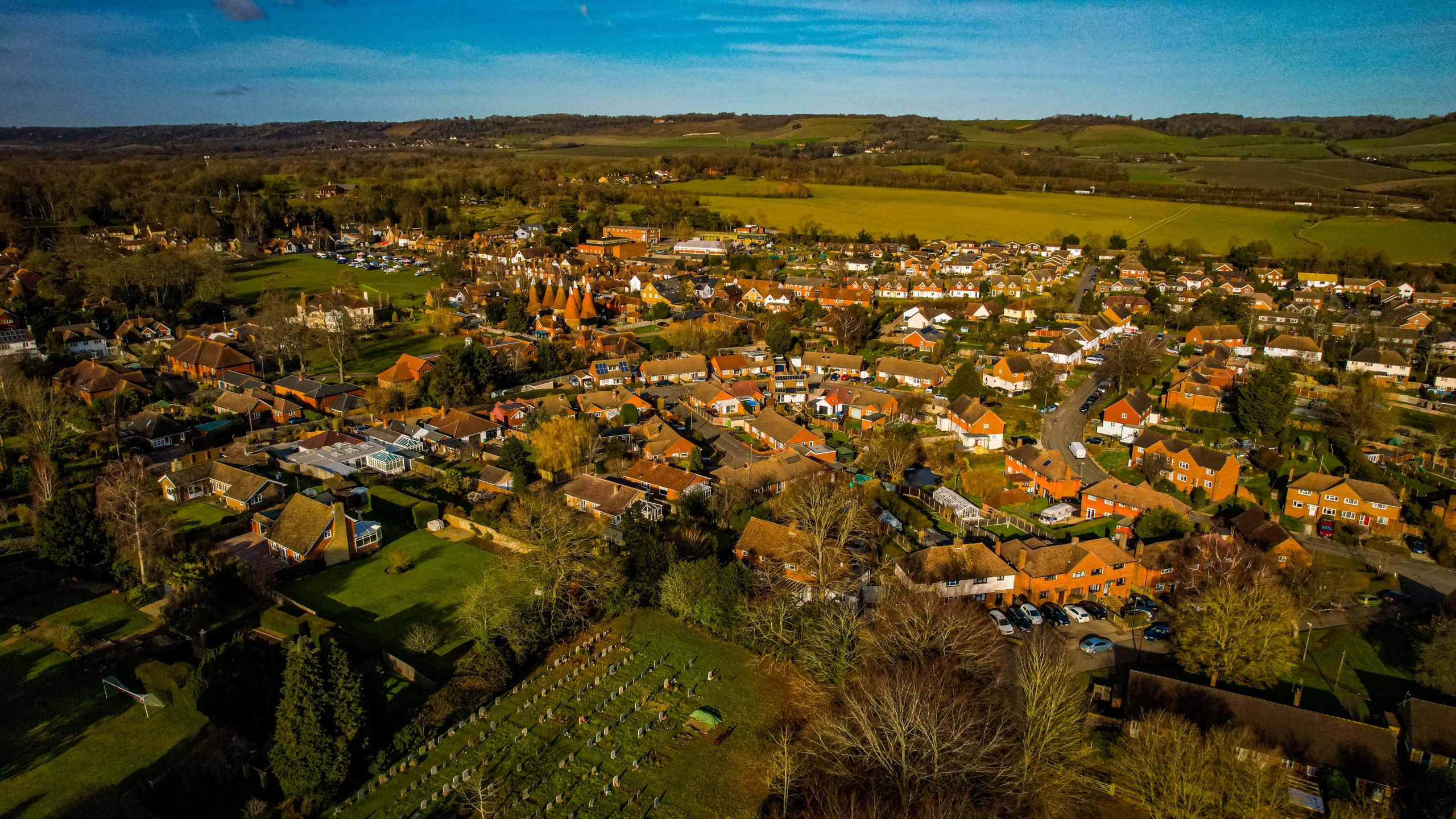 Aerial of Bearsted in the sun, the grass is green ad the buildings orange