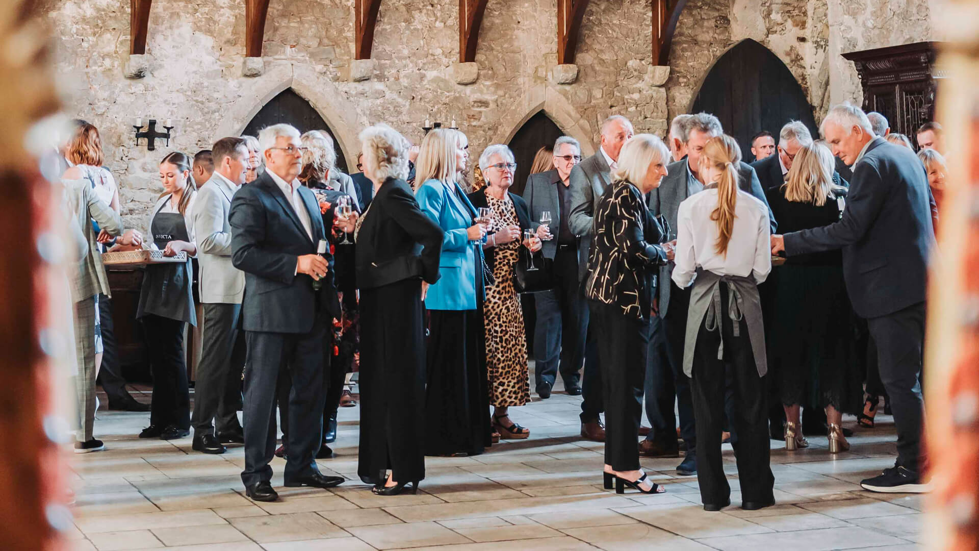 people talking inside a castle hall