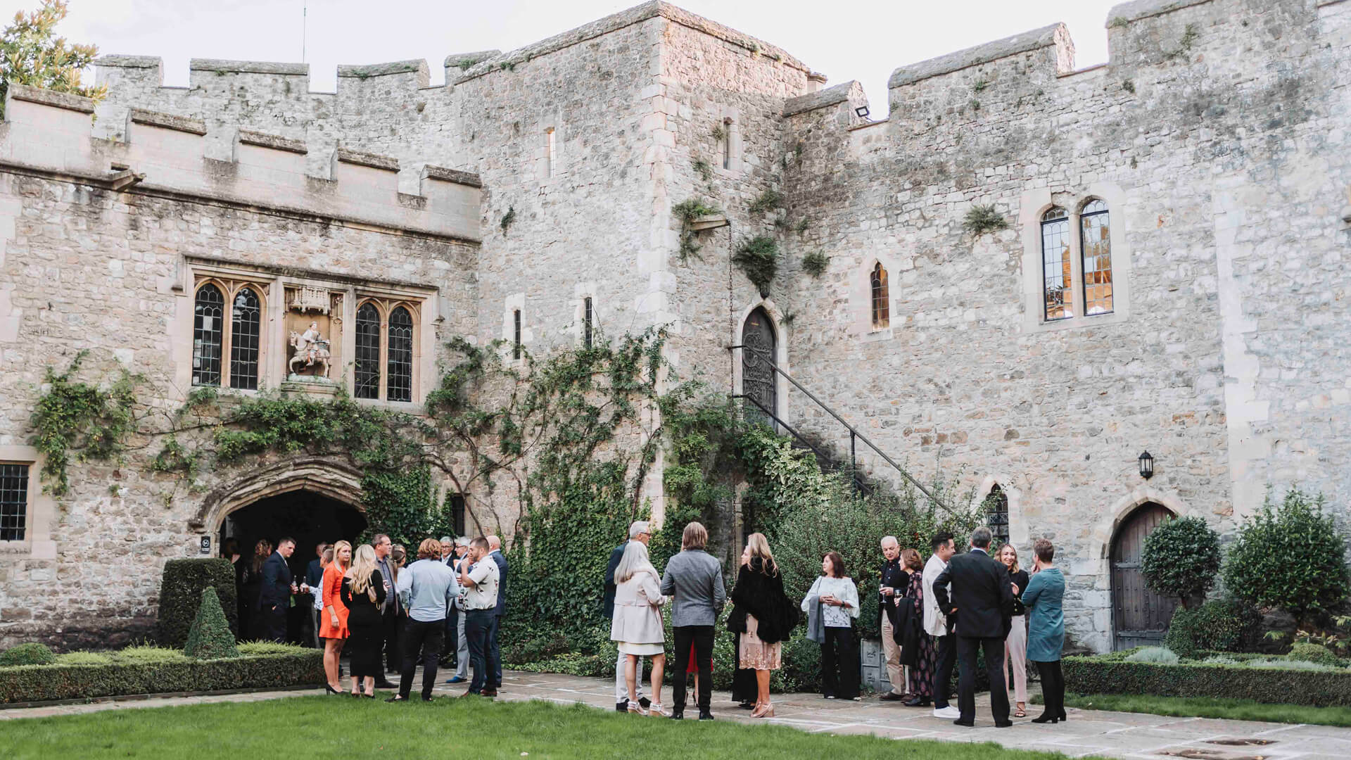 people talking outside in a castle courtyard