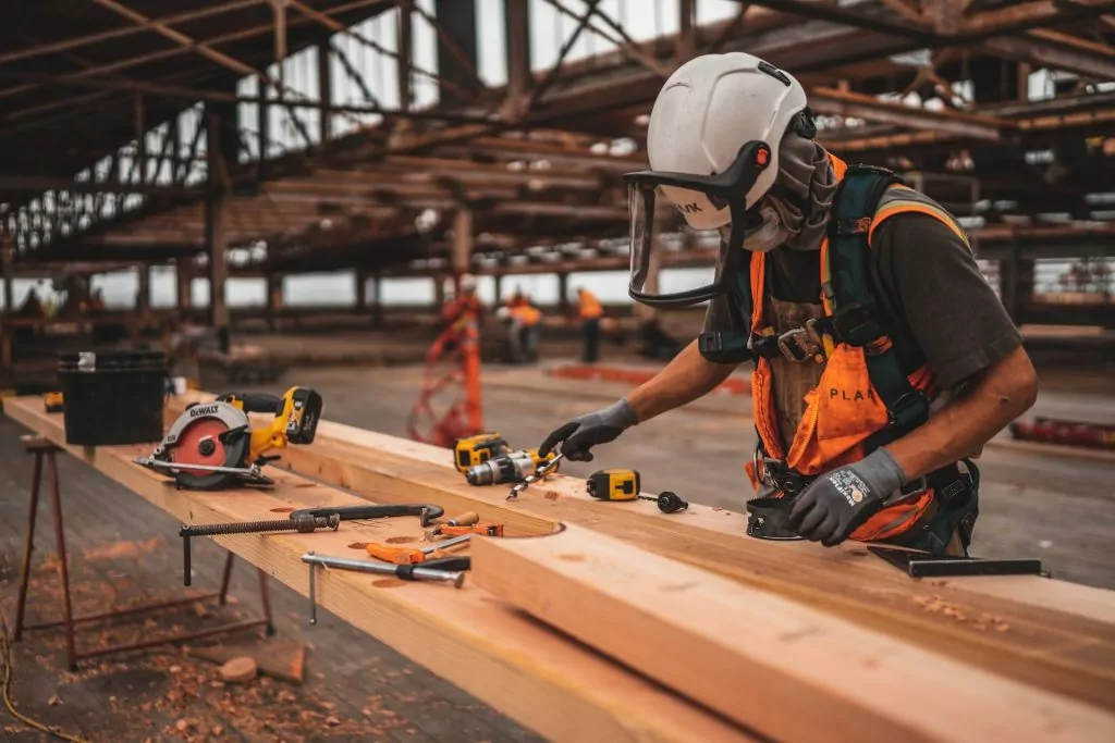 Construction worker with safety gear chopping wood