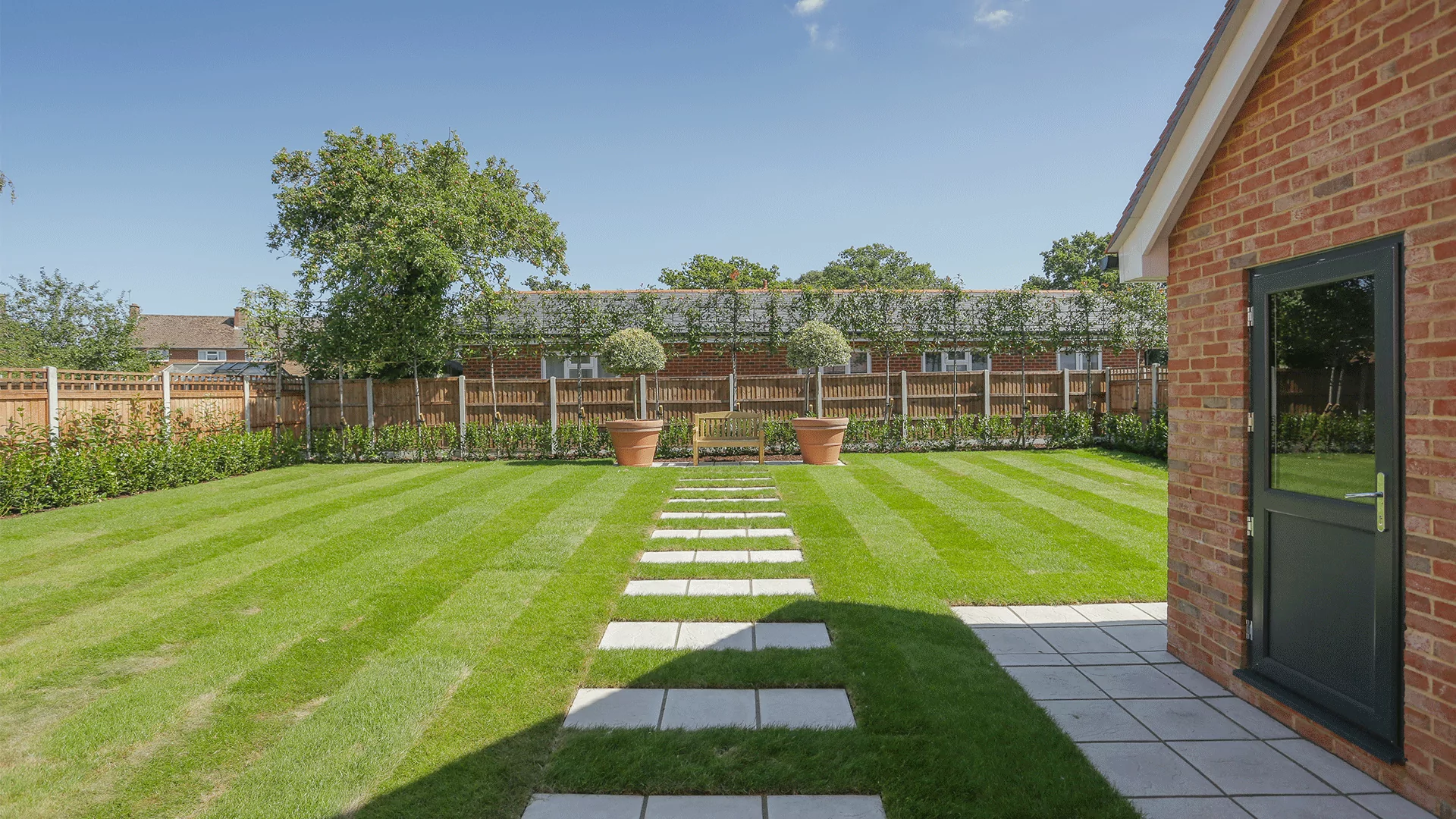 Miller's Meadow - Plot 8 Garden with a central path through grass and bench feature at the end