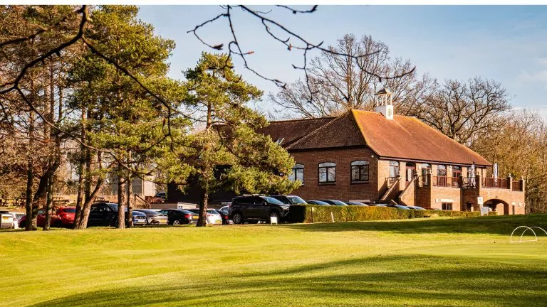 Looking over the golfing green you can see the car park and club house under the sun.